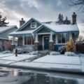 Snow-covered Idaho home with icicles hanging from clogged gutters, illustrating the risks of ice dams and the importance of professional gutter cleaning in Boise, ID.