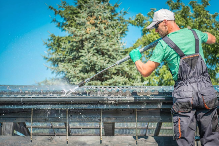 Professional pressure washing service cleaning a residential roof exterior