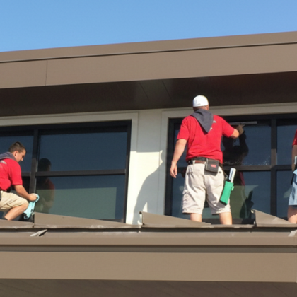 Professional window cleaners working on exterior glass of a commercial building